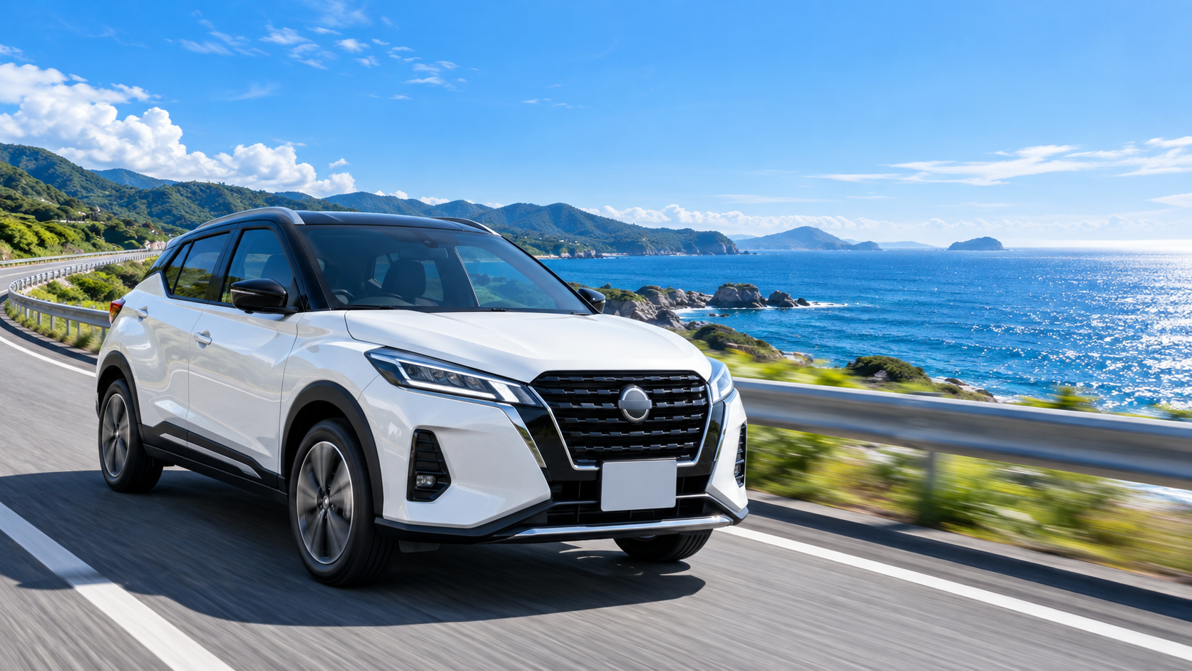 晴れた日の海沿いの道を走る白い日産キックス